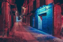 Perspective view to red and blue lit street facades — Stock Photo