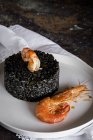 Black rice with prawns on white plate on rural table — Stock Photo
