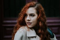 Young redhead woman posing on street and looking away. — Stock Photo