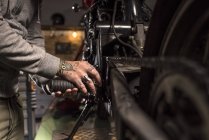 Руки на полях с татуировкой ремонта мотоцикла в мастерской — стоковое фото