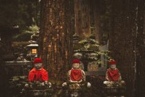 Three small Asian religious statues in forest. — Stock Photo