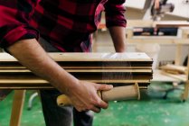 Cropped charpenter packaging planches en bois empilées — Photo de stock