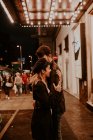 Vista lateral do casal abraçando na rua da noite — Fotografia de Stock
