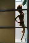 Vista inferiore della donna sensuale in topless sdraiata sul pavimento di vetro — Foto stock