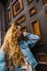 Sinnliche Frau in Jeansjacke posiert vor Holztür — Stockfoto