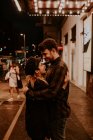 Усміхнена пара обіймається на вечірній вулиці — стокове фото