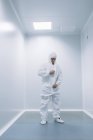 Дослідник людина надягає білий костюм перед дослідженням в лабораторії . — стокове фото