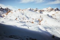 Отдаленный взгляд на человека, путешествующего по снежной горе — стоковое фото
