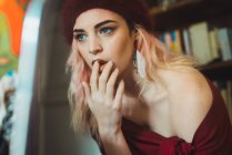 Attractive woman posing with finger on lips — Stock Photo