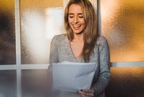 Laughing blonde woman with papers — Stock Photo