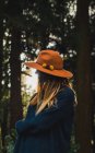 Jovem mulher de chapéu posando na floresta ensolarada — Fotografia de Stock