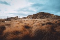 Vista alla piccola casa sul campo a collina rocciosa . — Foto stock