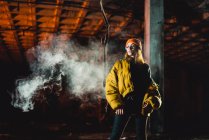 Pretty woman vaping in abandoned building at night — Stock Photo