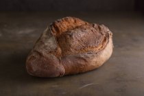Vista de cerca del pan recién horneado sobre fondo oscuro - foto de stock