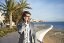 Uomo d'affari casual Parlare su smartphone sulla spiaggia urbana — Foto stock