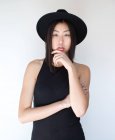 Jeune femme asiatique posant en studio avec chapeau — Photo de stock