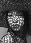 Asian woman in big hat and shadows on face — Stock Photo