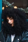 Portrait de femme aux cheveux bouclés posant en regardant la caméra — Photo de stock