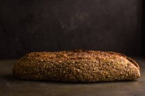 Nature morte de pain fraîchement cuit sur fond sombre — Photo de stock