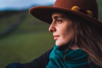 Мечтательная женщина позирует на фоне зеленого поля — стоковое фото