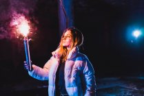 Hübsche Frau posiert nachts mit brennender Fackel — Stockfoto