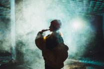 Side view of woman vaping in abandoned building — Stock Photo