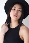 Young woman with hat posing in studio on white backdrop — Stock Photo