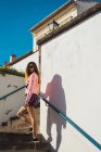 Jolie femme en lunettes de soleil posant sur les marches de la rue . — Photo de stock
