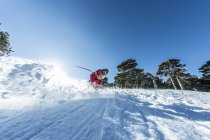 Man practicing speed skiing on slope under blue sky — Stock Photo