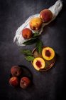 Stillleben frischer Pfirsiche auf dunklem Tisch. — Stockfoto