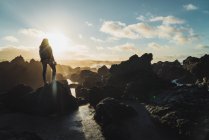 Silhouette de femme avec caméra sur les falaises — Photo de stock