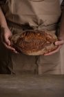 Mittelteil des Mannes hält frisch gebackenen Brotlaib — Stockfoto