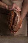Обрізати чоловічі руки, тримаючи свіжоспечений хліб — стокове фото