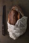Pão recém-assado em toalha no fundo escuro — Fotografia de Stock