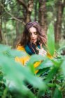 Pensive woman walking through leaves in forest — Stock Photo