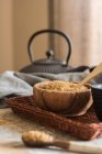 Ciotola di legno piena di canna da zucchero marrone su vassoio di vimini — Foto stock