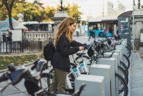 Side view of blonde woman taking bicycle in park — Stock Photo