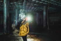 Donna che vaporizza in un edificio abbandonato di notte — Foto stock