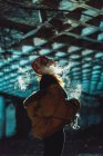 Woman vaping in abandoned building at night — Stock Photo
