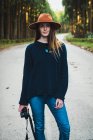 Фотограф в капелюсі позує на сонячній лісовій алеї — стокове фото