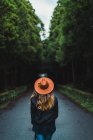 Visão traseira da mulher andando na estrada na floresta — Fotografia de Stock
