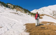 Rückansicht einer Wanderin, die mit Schnee den Berg hinauf geht — Stockfoto