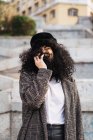 Laughing woman hiding face in curly hair at park — Stock Photo