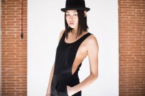 Mulher elegante em chapéu preto e elegante global no fundo branco — Fotografia de Stock