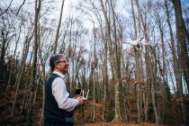 Homem alegre voando drone com controle remoto no campo — Fotografia de Stock