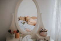 Reflexão da jovem mulher em lingerie dormindo na cama em casa . — Fotografia de Stock