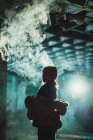 Silhouette of woman vaping in abandoned building — Stock Photo