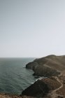 Vista a las rocas costeras y el mar tranquilo en día nublado gris . - foto de stock