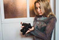 Junge blonde Frau blickt in die Kamera in Händen — Stockfoto