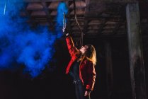 Жінка позує з синім смолоскипом у покинутій будівлі — стокове фото